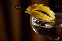 Close-up of lemon peel garnish on a cocktail in a coupe glass